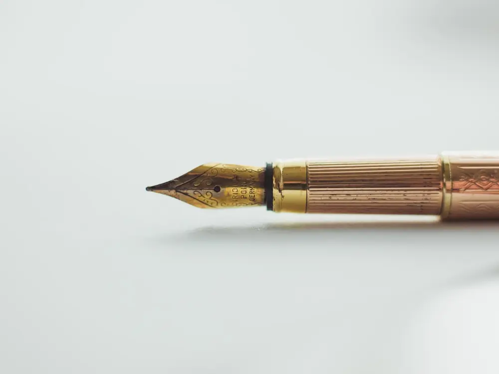 A gold fountain pen nib on a pale surface